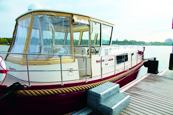 Riverboat mit Persenning am Steg